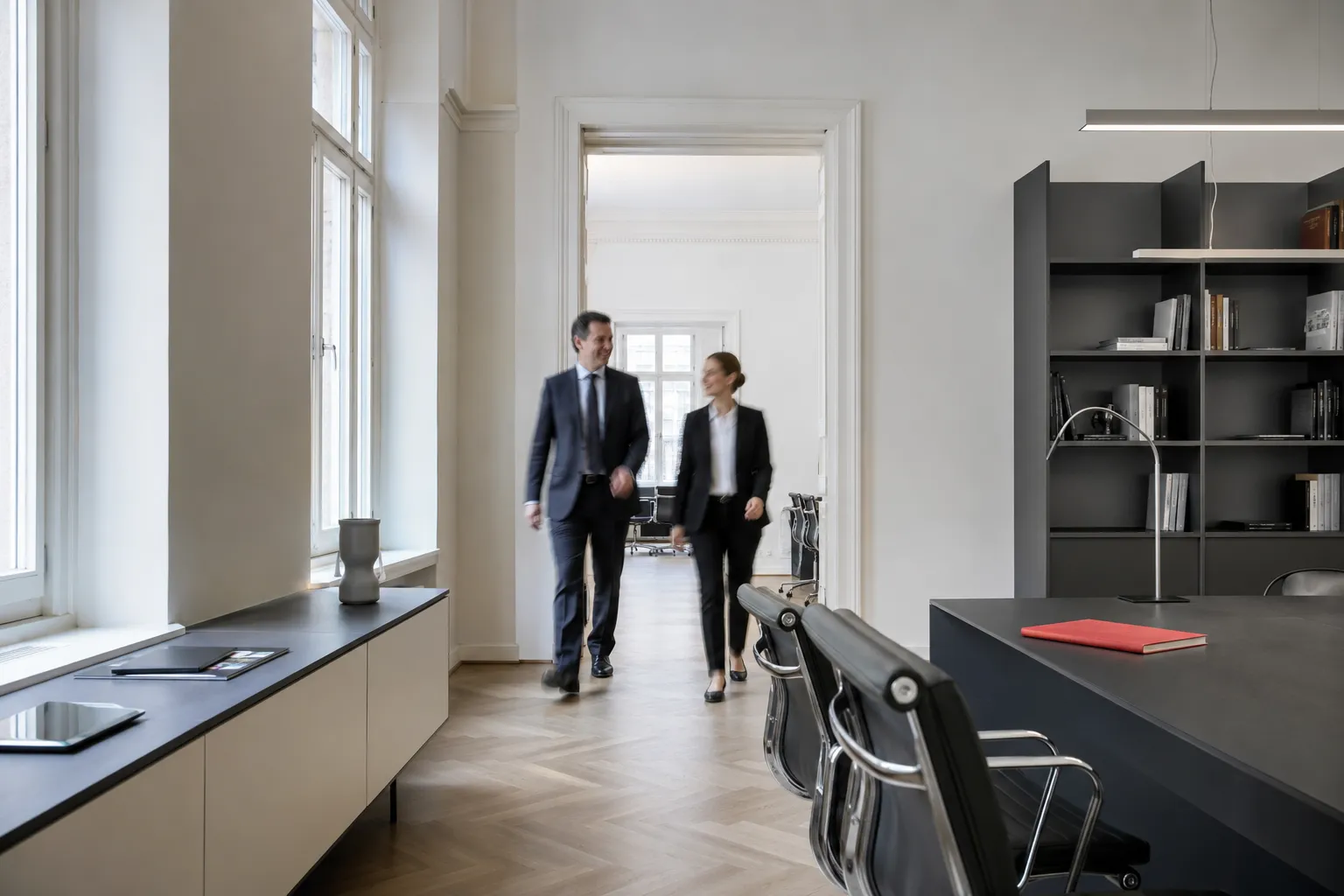 A formal modern office in Vienna with tall windows.
